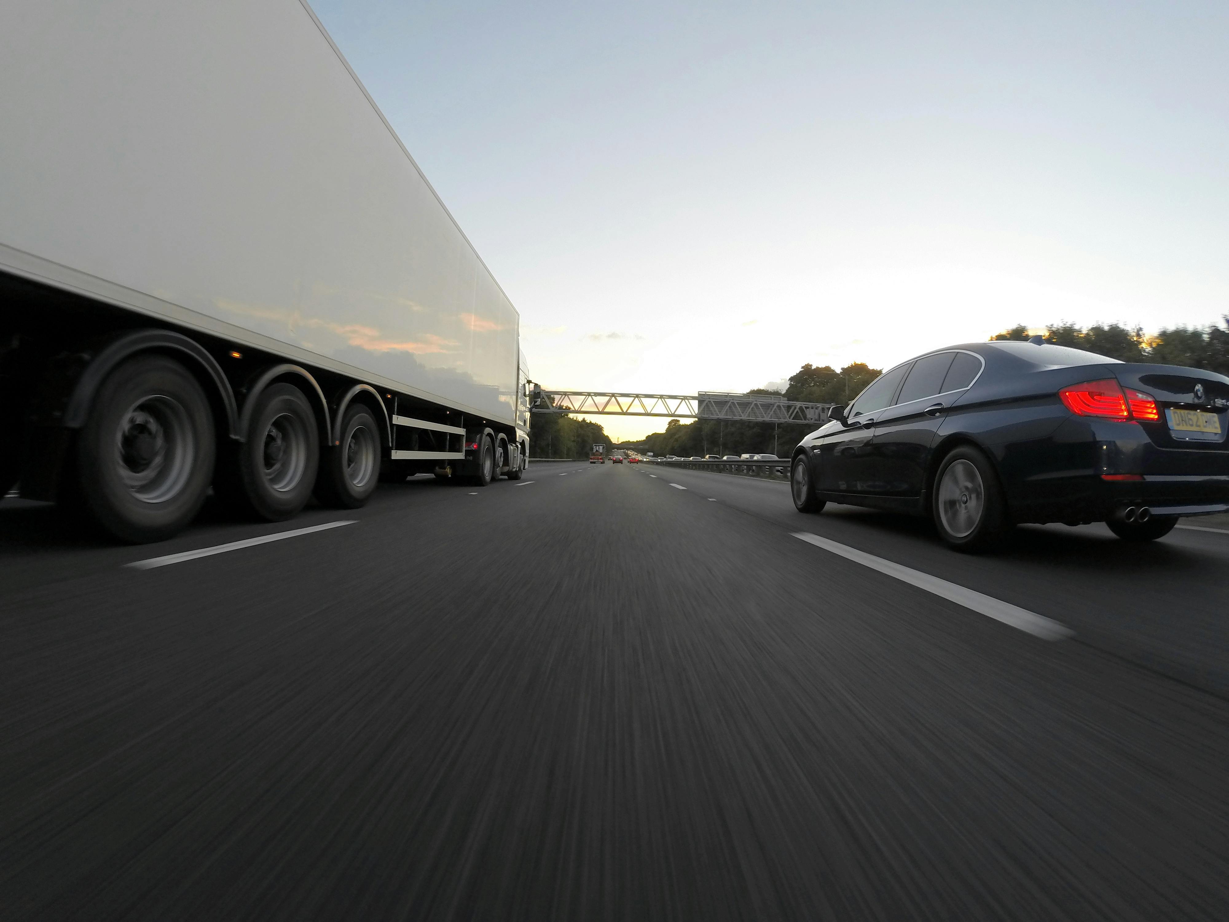lorry and car driving side-by-side on road